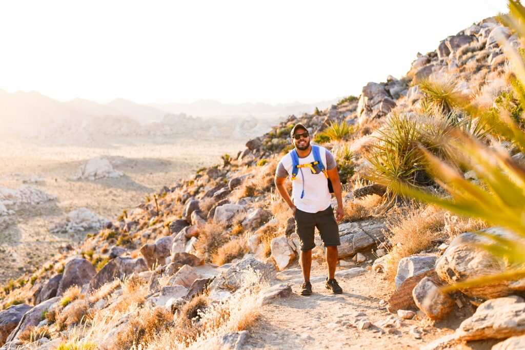 Male hiker in front of desert landscape at sunset