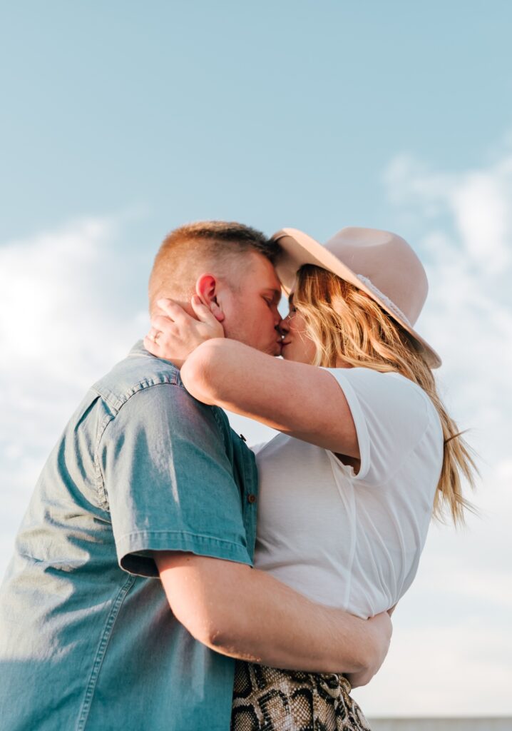 couple kissing with sky behind