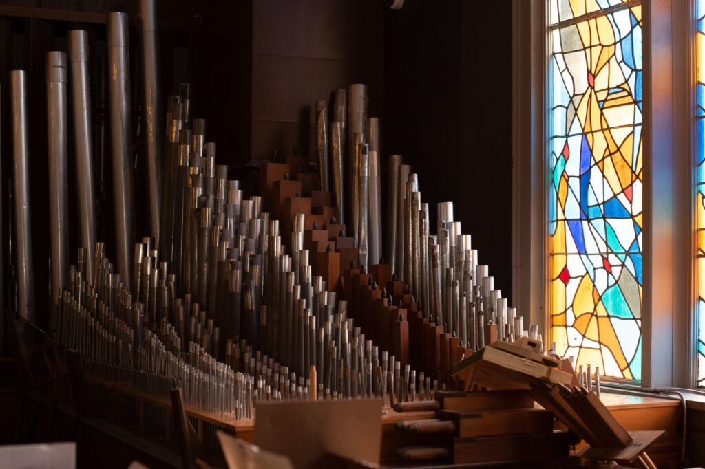 Organ pipes in front of a mosaic window