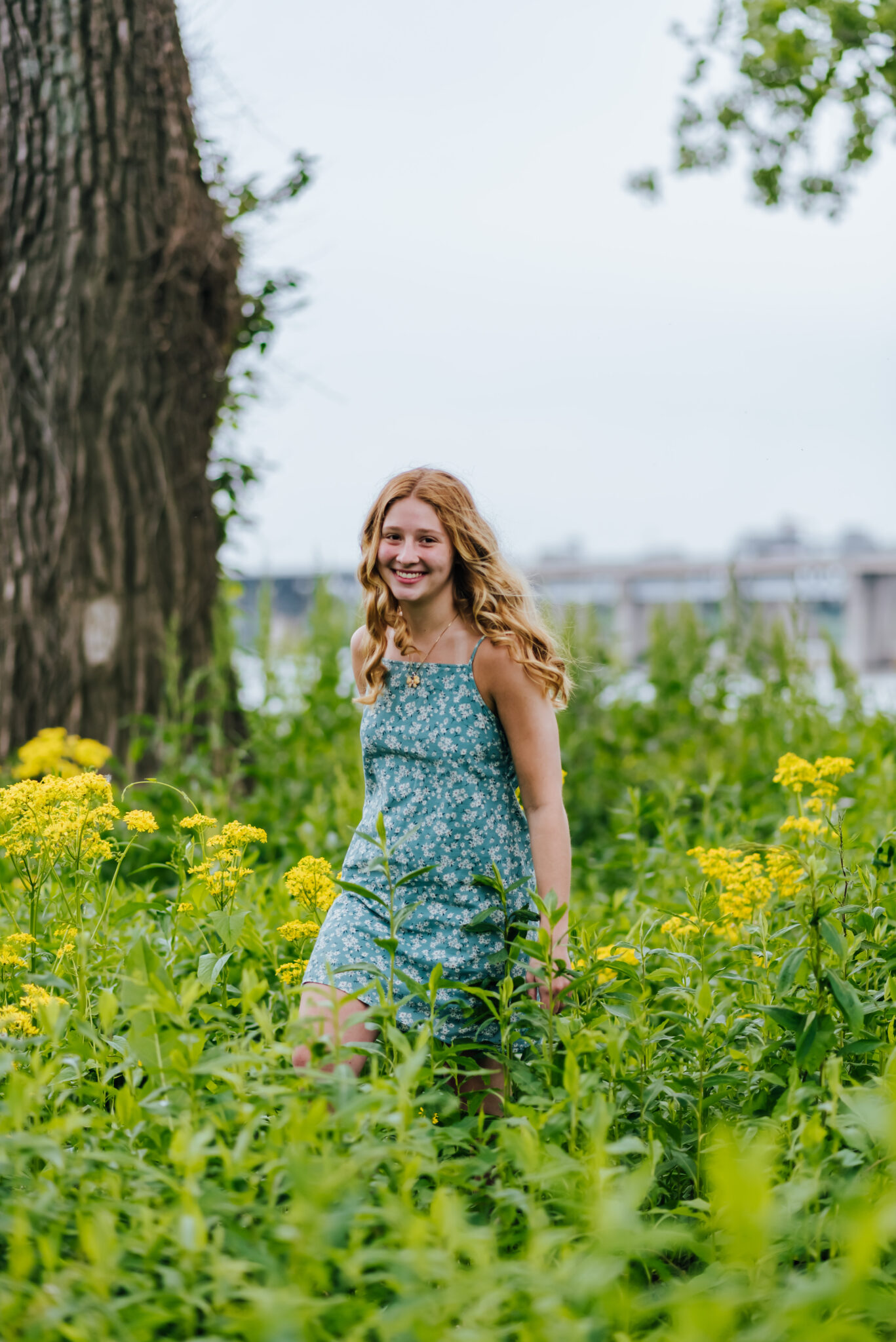 Redhead walks through tall grass and yellow flowers