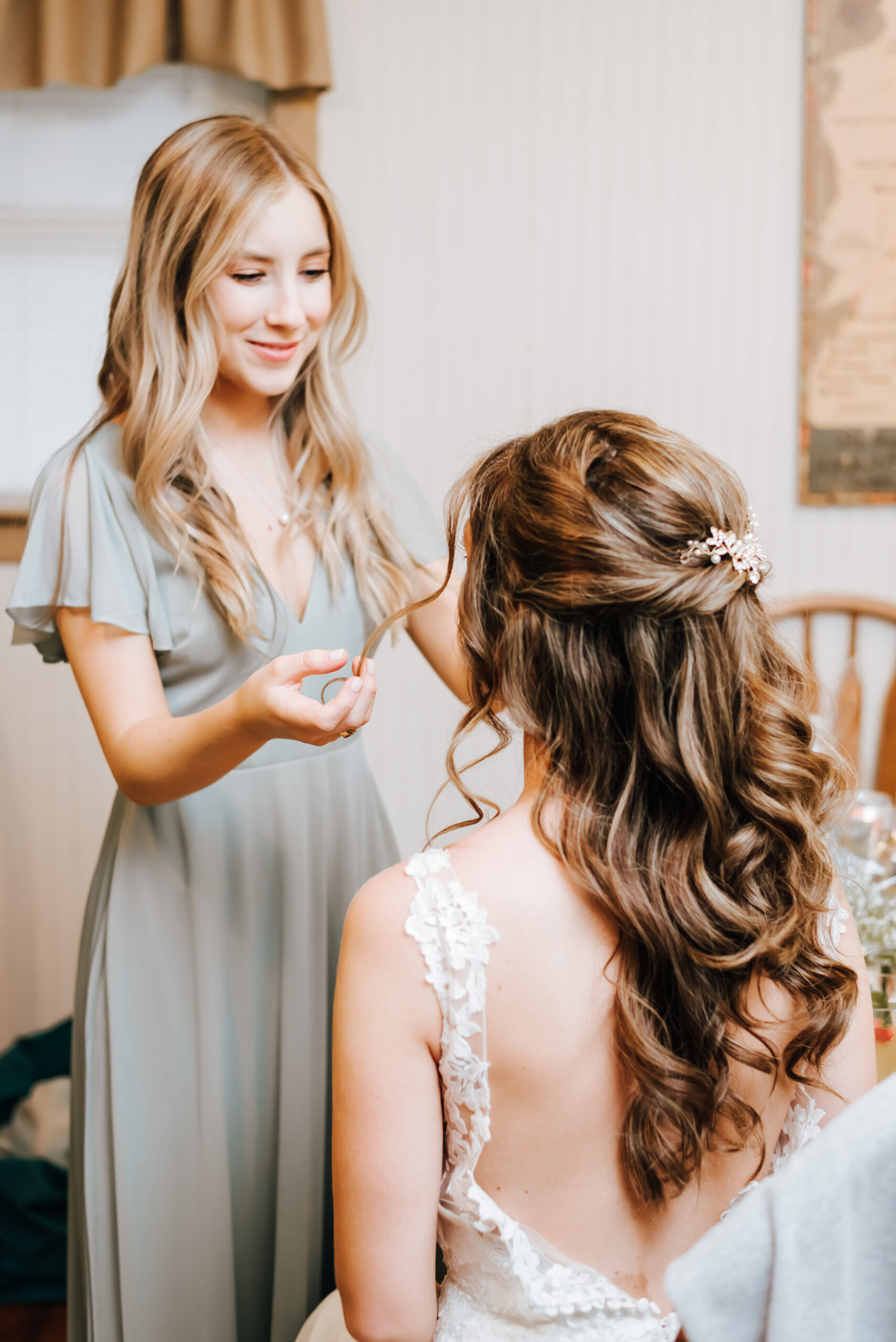 Bride's sister does final touch ups on the bride's hair