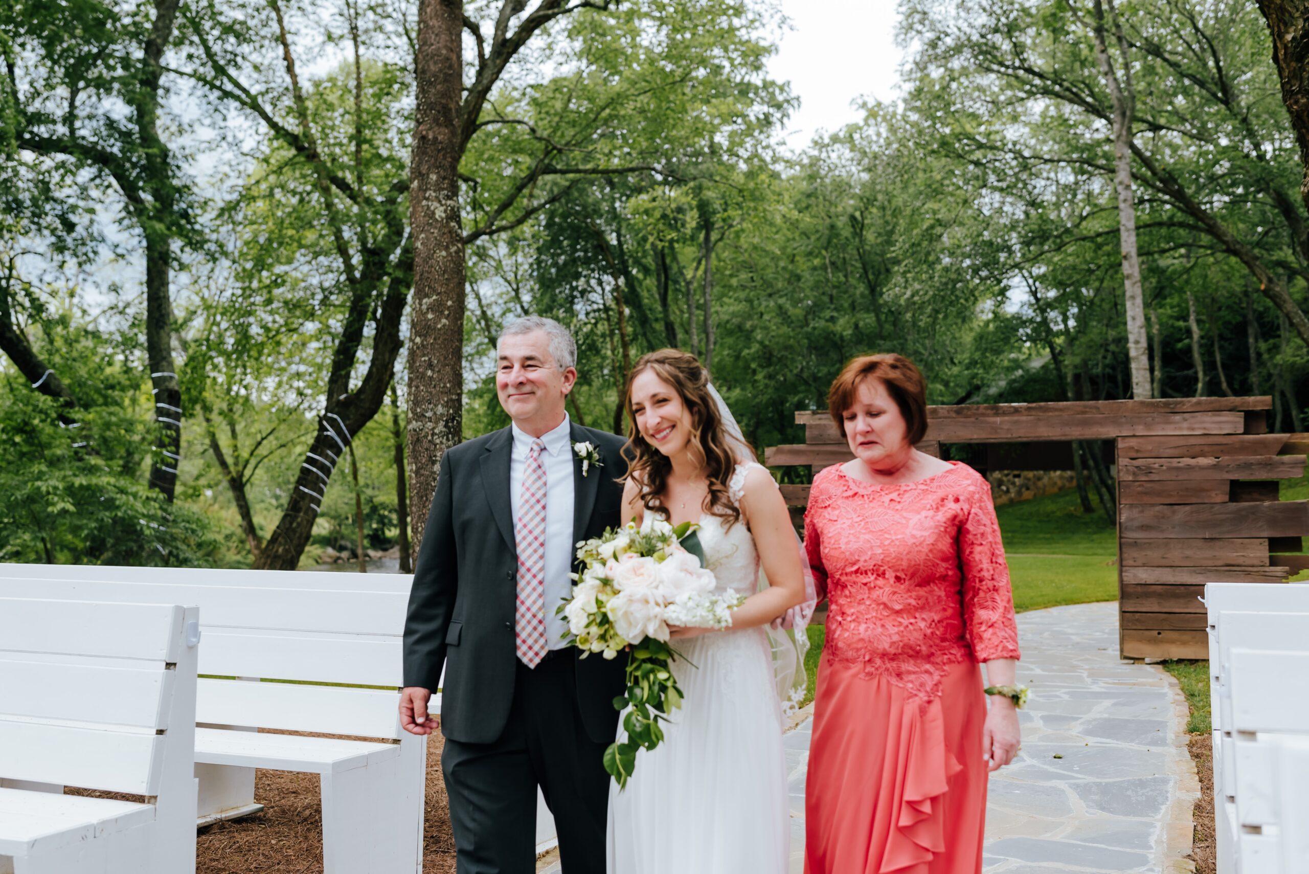 Bride walks down the aisle with her parents