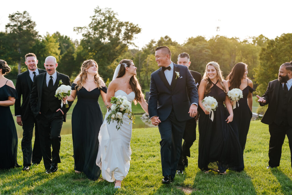 Newlyweds smile and walk with their wedding party