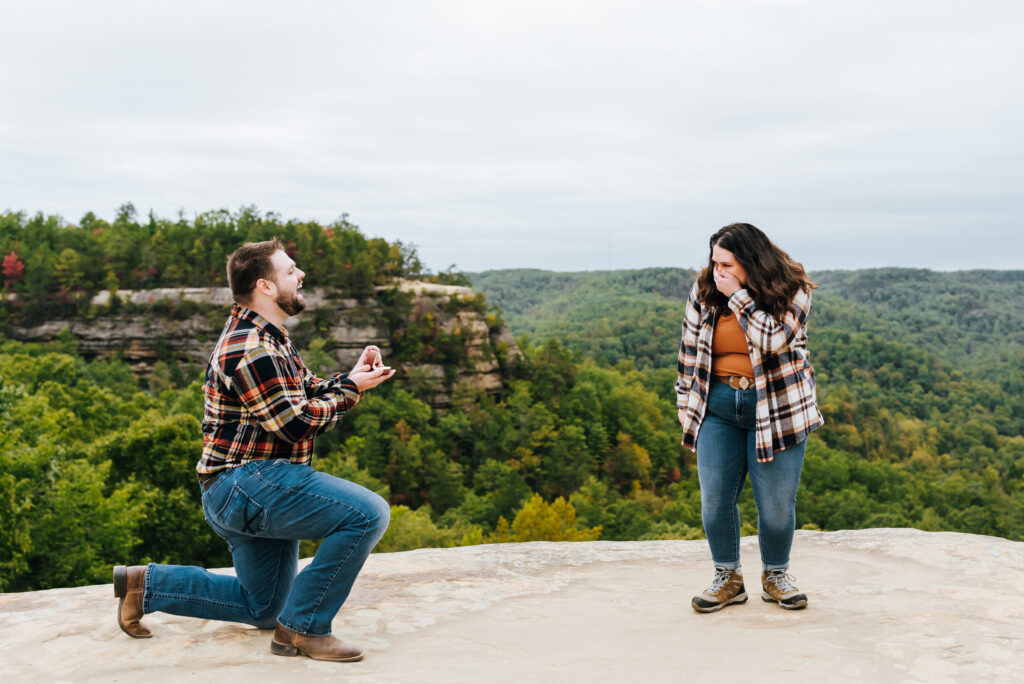 A woman is shocked when her boyfriend surprises her by dropping to one knee for a proposal