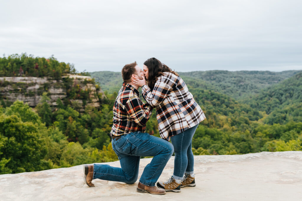 The couple share a kiss after she says yes