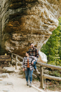 A couple poses underneath the Natural Bridge at Red River Gorge