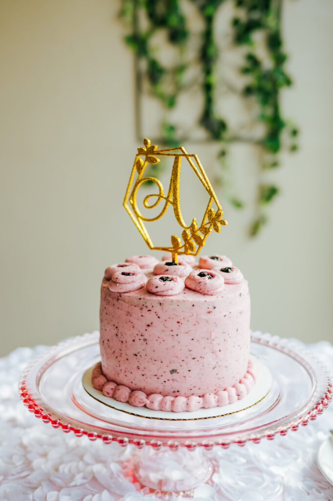 A petite pink cake with a monogrammed A topper