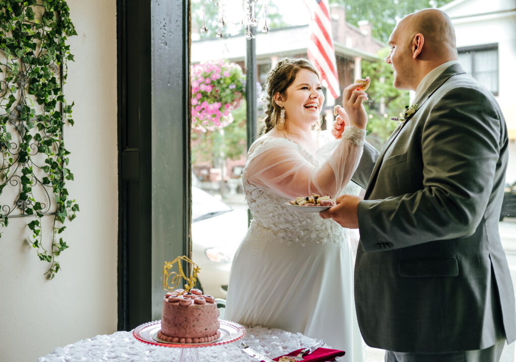A newly wed couple feeds each other wedding cake