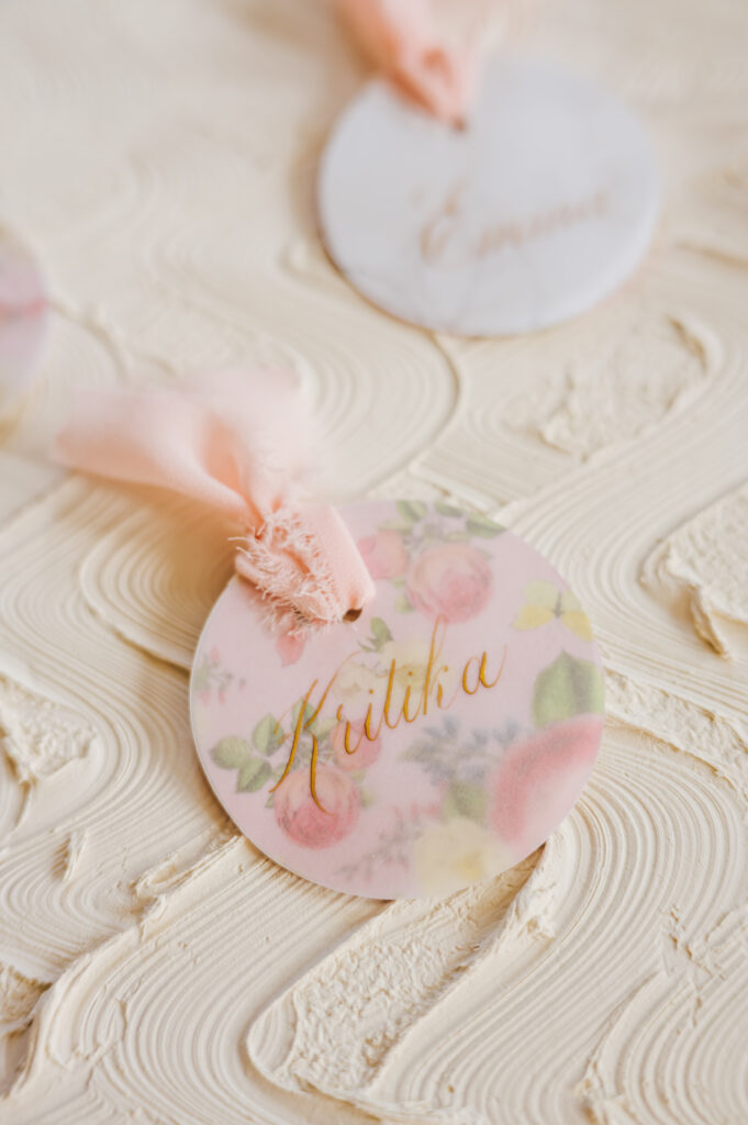 A light pink flowery ornament that has been calligraphed for a wedding favor