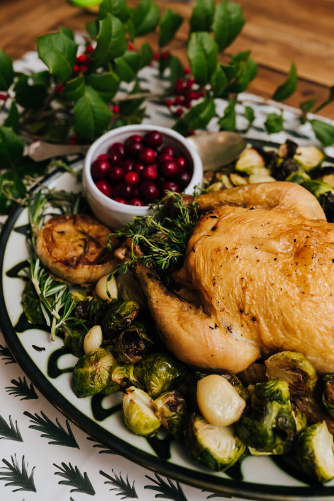 A plate of Thanksgiving turkey on a plate with vegetables and cranberry sauce