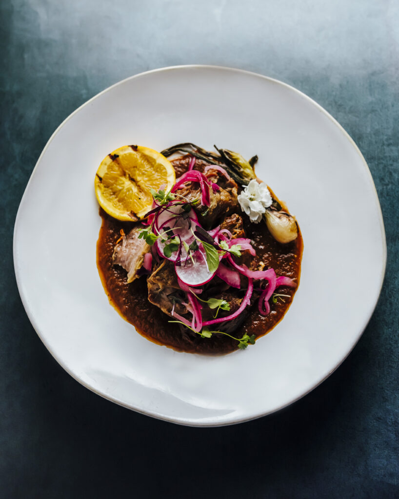 A plated smoked brisket on a dark blue background