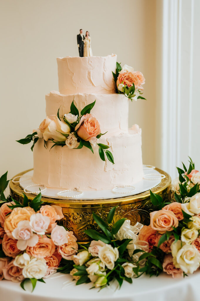 A peachy toned cake with a traditional cake topper