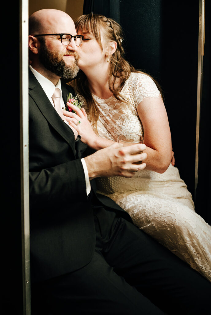 The newlyweds share a kiss inside the photobooth