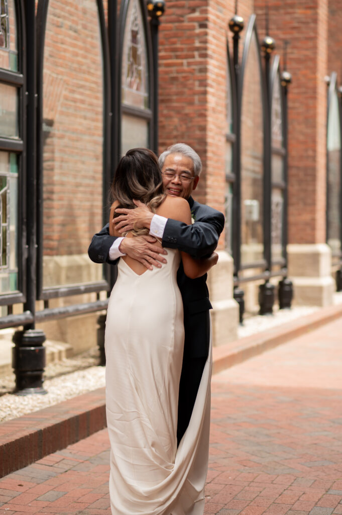 The bride hugs her father while they share an emotional moment together for a first look before the ceremony.