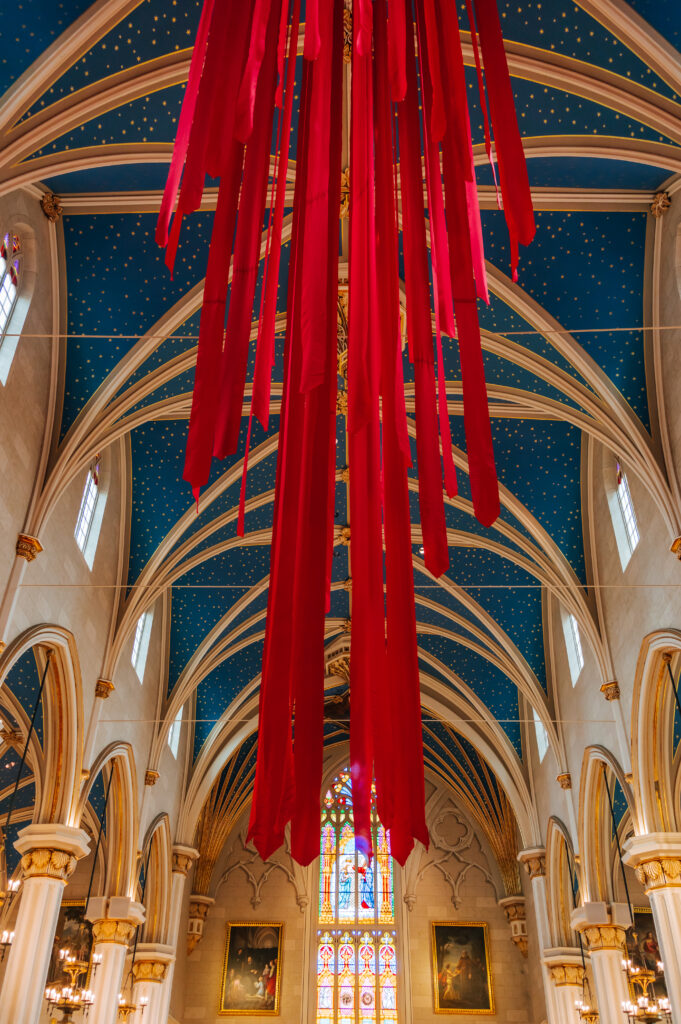 Red streamers for Pentecost hang from the ornate vaulted ceilings of the Cathedral of the Assumption