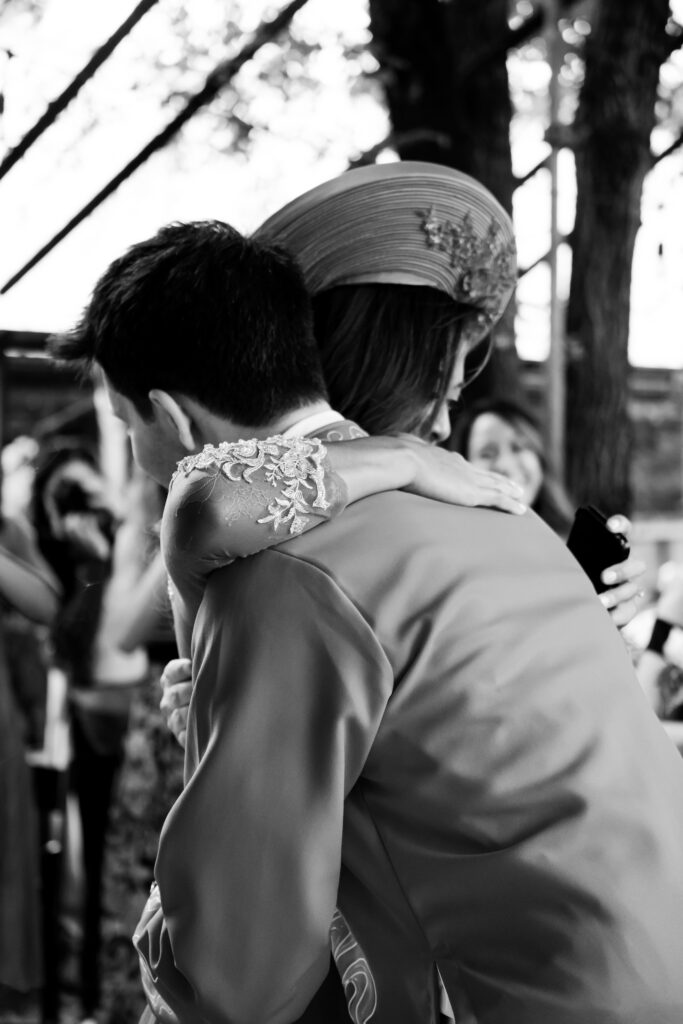 A black and white photo of the bride and groom embracing after reading their vows to each other