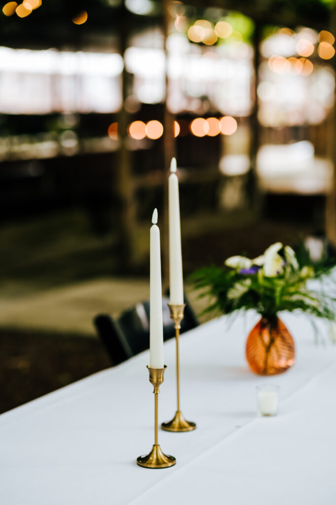 Two candlesticks sit atop a reception table