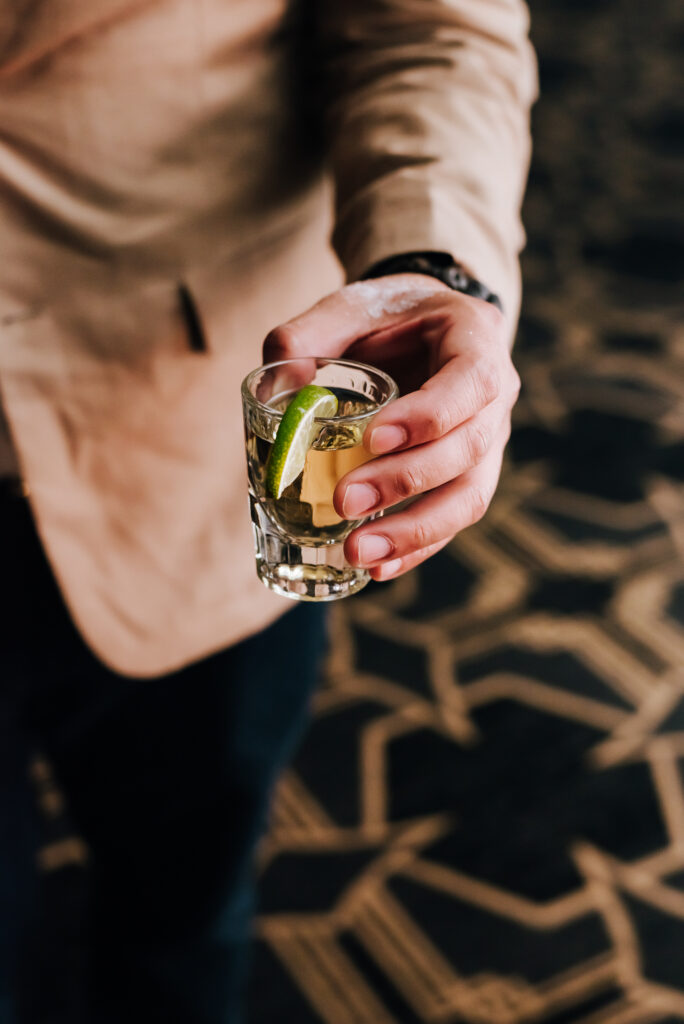 A guest holds a tequila shot in hand