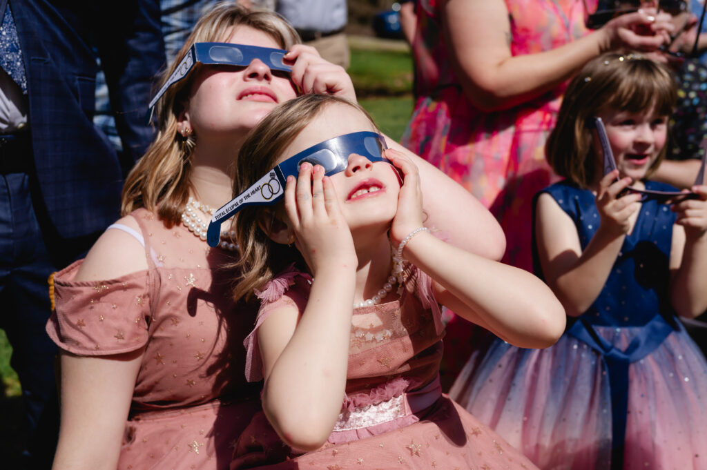 The couple's daughters gaze up at the sky with their eclipse glasses on