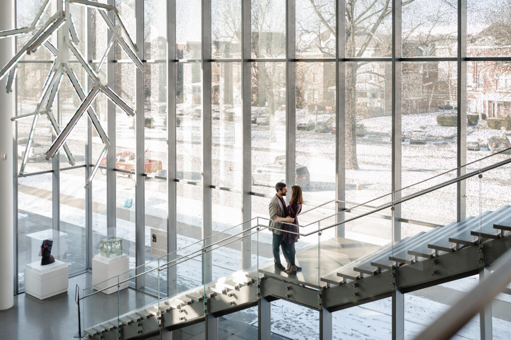 A couple embraces in the middle of the glass staircase at the Speed Art Museum