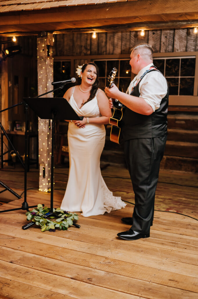 Bride Jacquelyn smiles and looks at her new husband while she sings Shania Twain's "You're Still the One." Groom Jonathan smiles back as he plays the guitar.