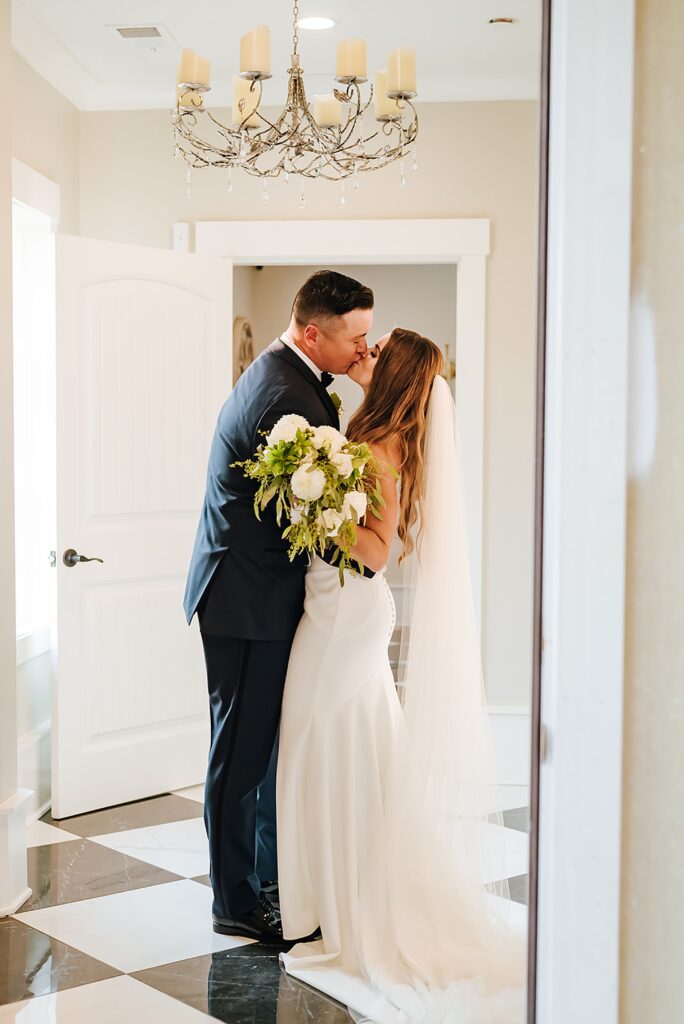 A bride and groom kiss in the hall of a historic wedding venue in Louisville.