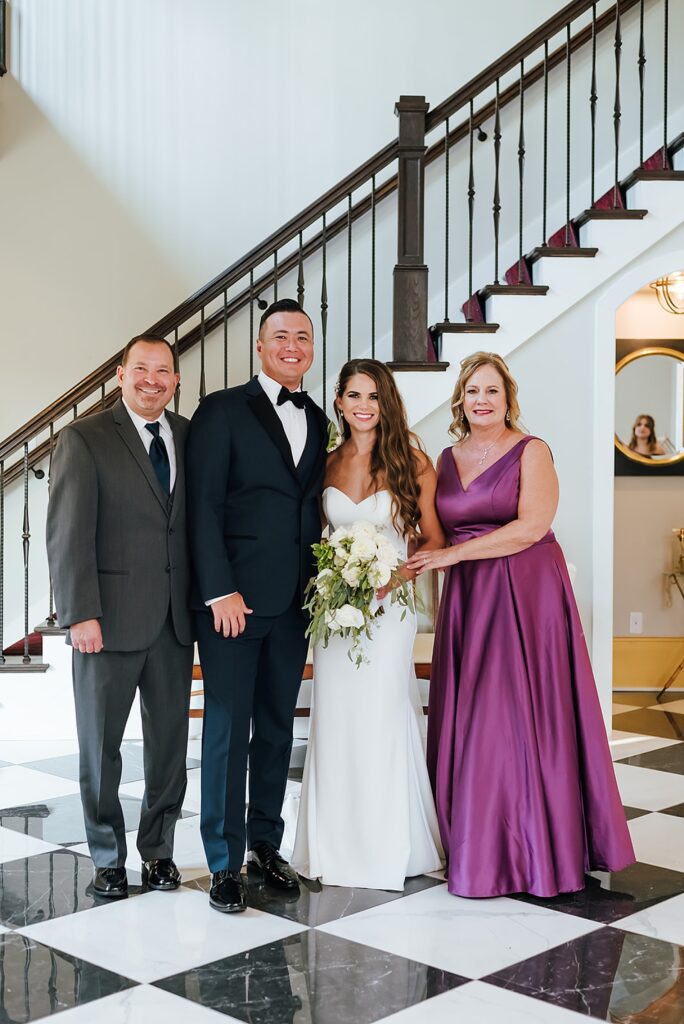 A bride and groom pose with their parents for a Louisville wedding photographer.