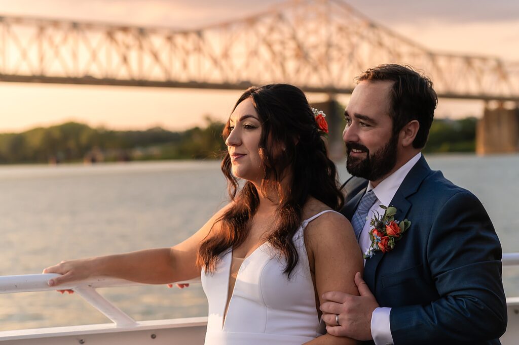 A bride leans against a groom on the deck of the CQ Princess in Louisville.