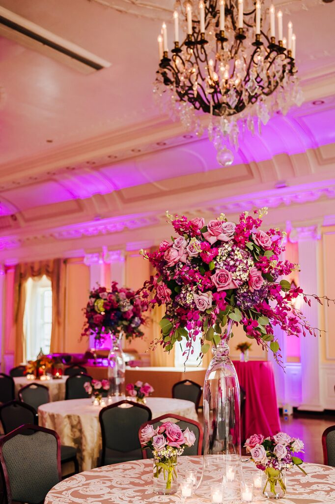 A floral arrangement sits on a wedding reception table inside a wedding venue in Louisville.