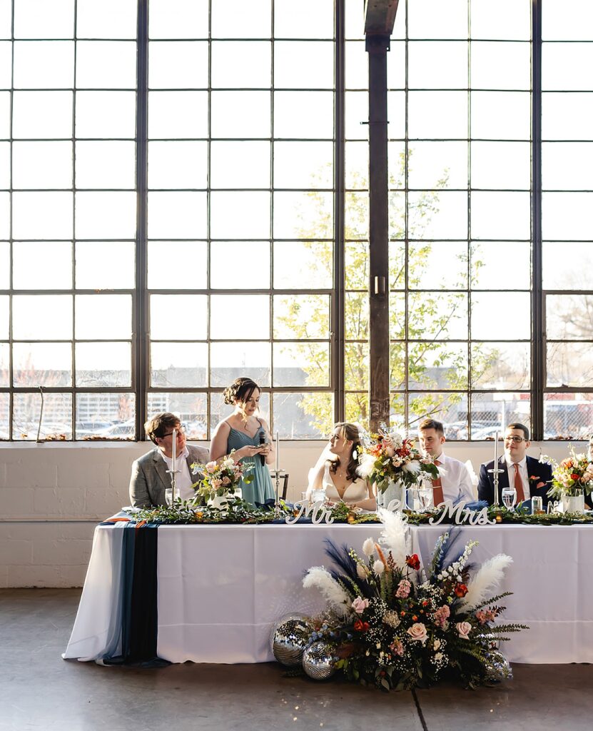 A bridesmaid gives a wedding toast at a head table during a Louisville wedding.