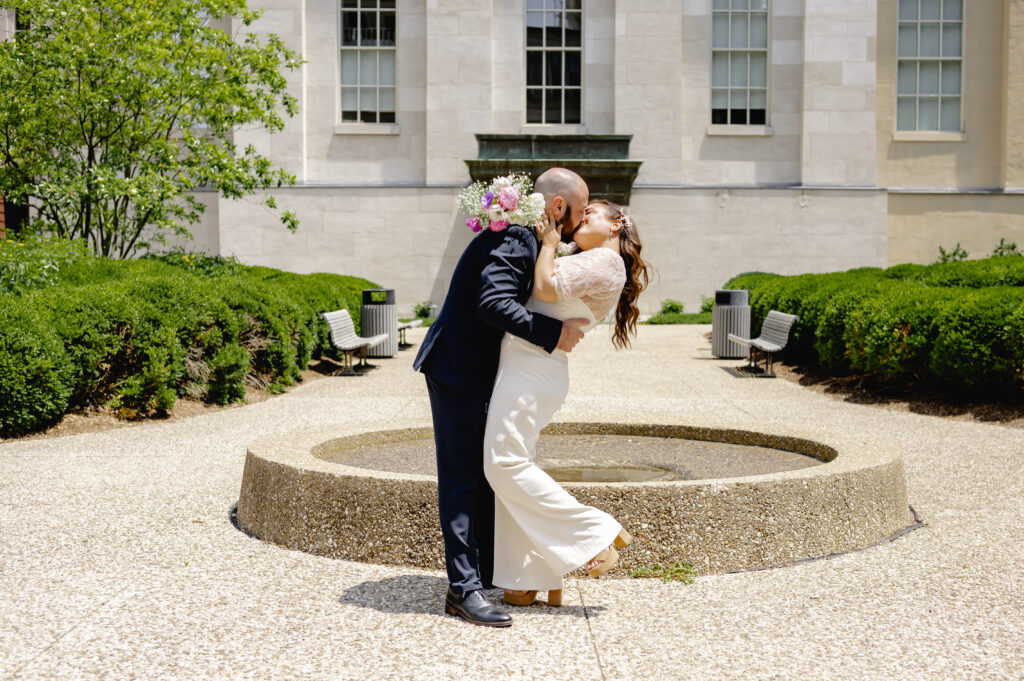 A newly married couple does a dip while sharing a just married kiss in the courtyard outside the Downtown Louisville Hall of Justice