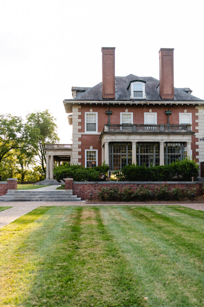 The exterior grounds of Gardencourt show the sunroom, the manicured lawn and a sunlit porch