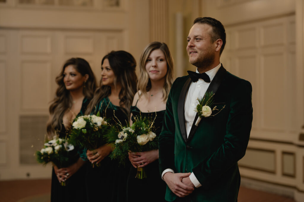 Matthew looks at his groom and mother coming down the aisle. Next to Matthew, his younger sister is visibly emotional as she looks at him.