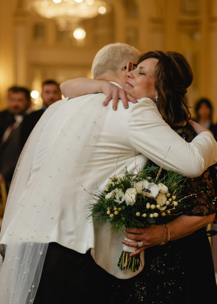 Jared hugs his mother in law as he escorts her to her seat