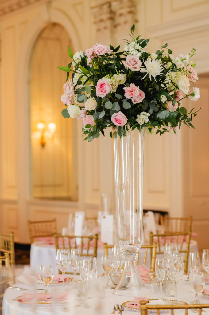 Tall centerpieces with pink and white florals adorn the reception tables.