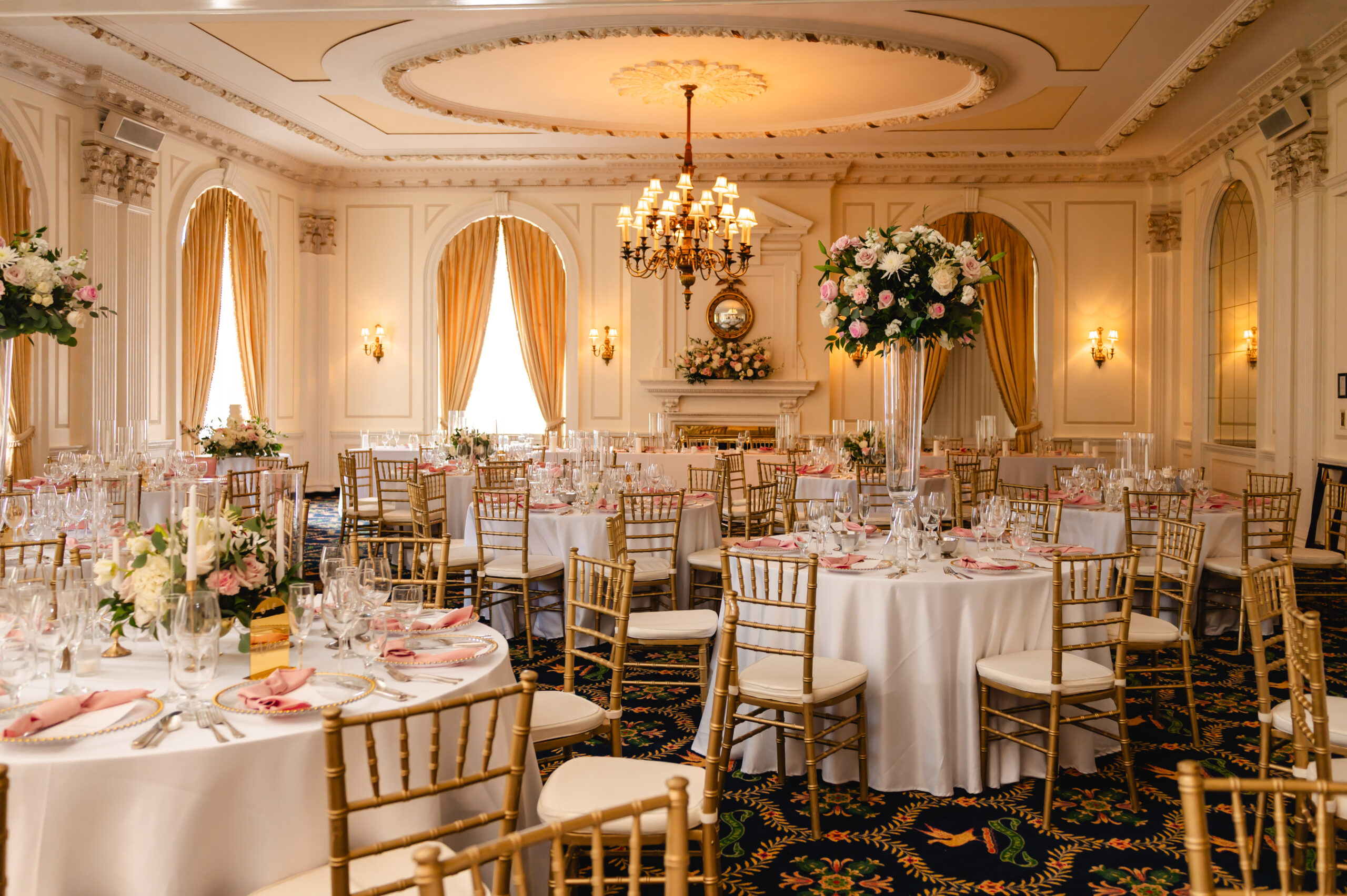 An elegant reception setup at the Pendennis Club with round tables and tall centerpieces in the grand ballroom.