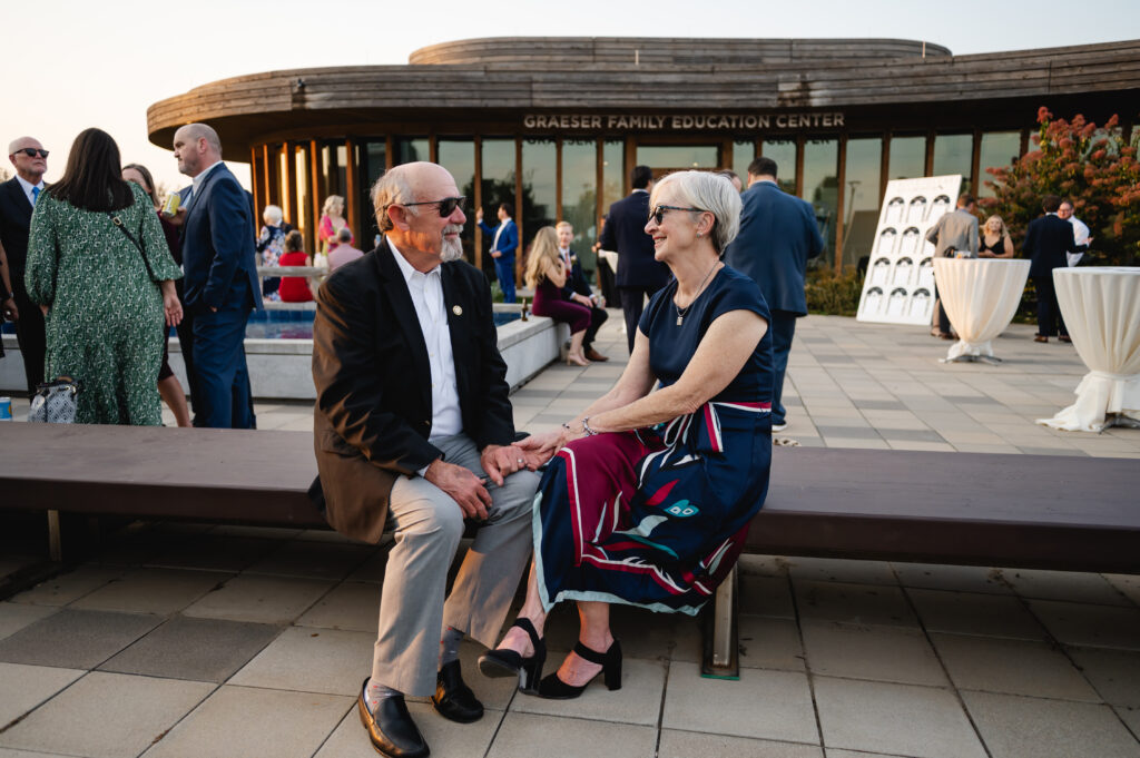 An older couple enjoys cocktail hour al fresco at the Waterfront Botanical Gardens