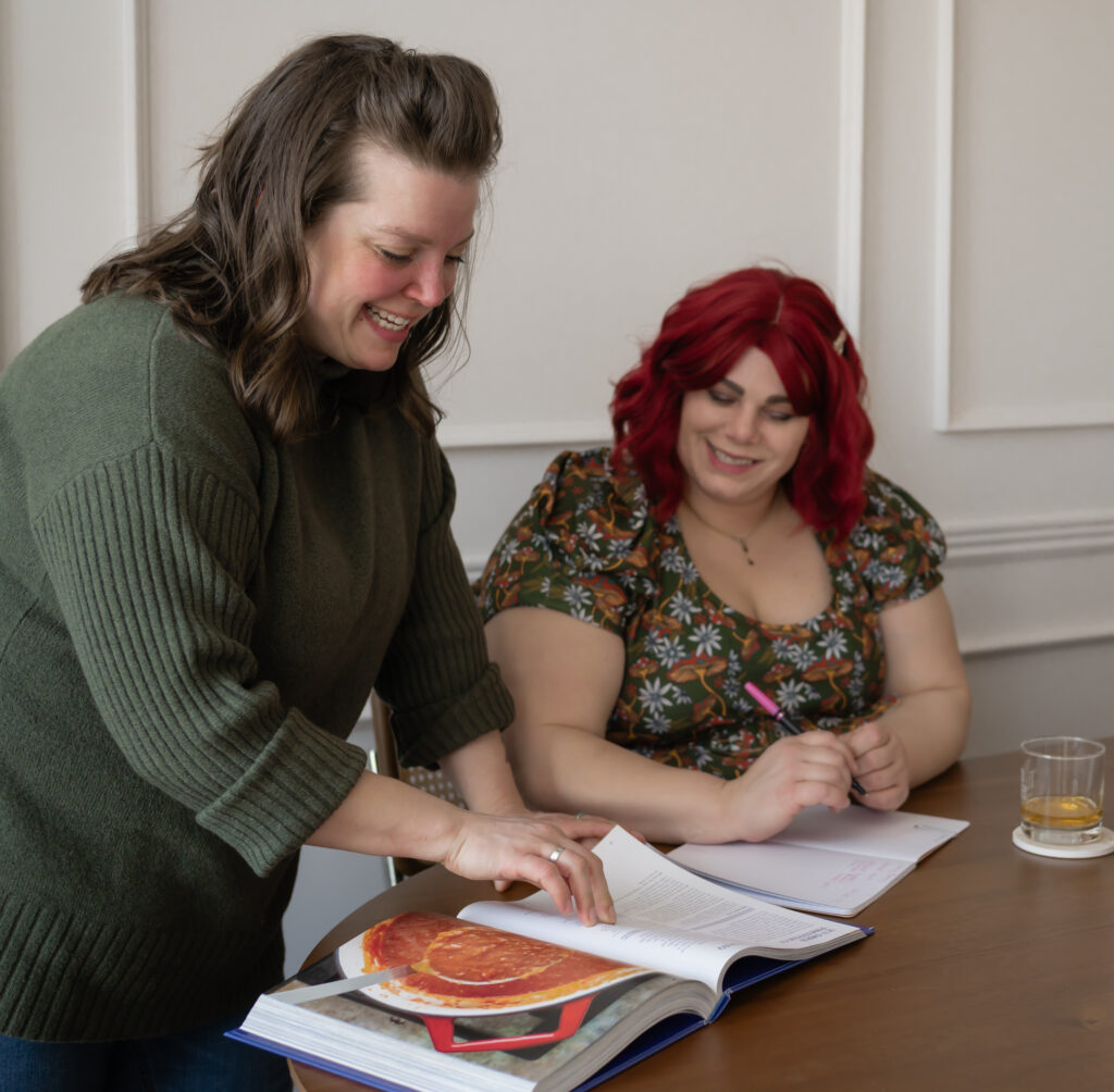 The chef and her manager look through cookbooks for inspiration in this lifestyle brand photo.