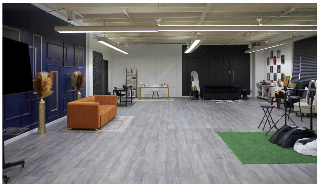 Studio B of the same studio is a massive space that has four different wall installations (black, white, navy, pink) with crown moulding and furniture to match. There is also a large area for paper backdrop stands and many props visible.