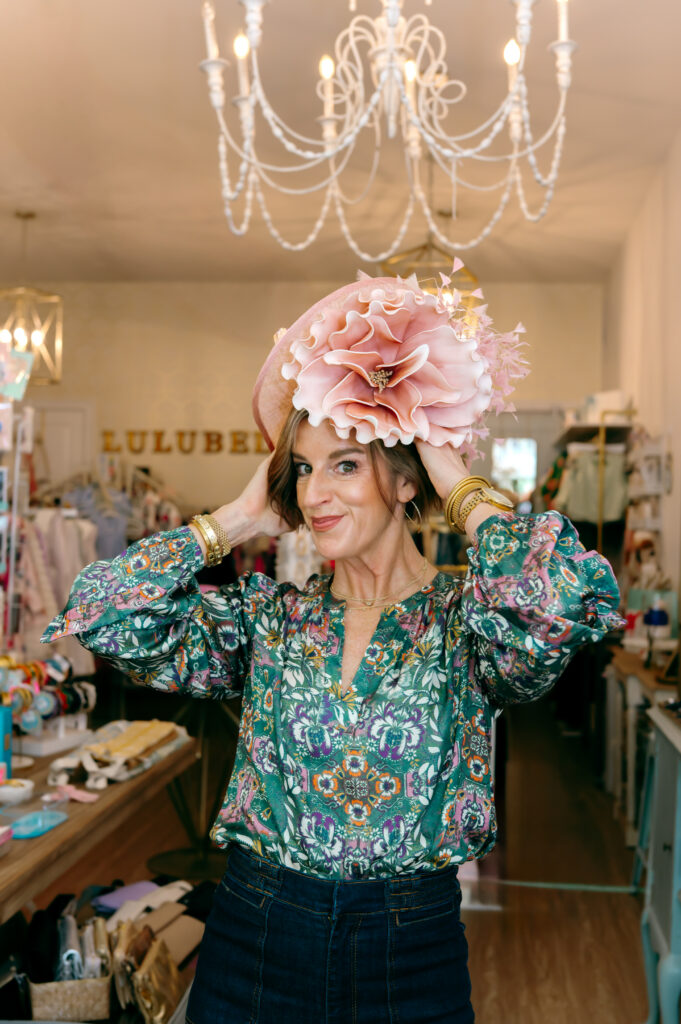 A wardrobe stylist tries on a derby fascinator in Lulubelle's at Norton Commons
