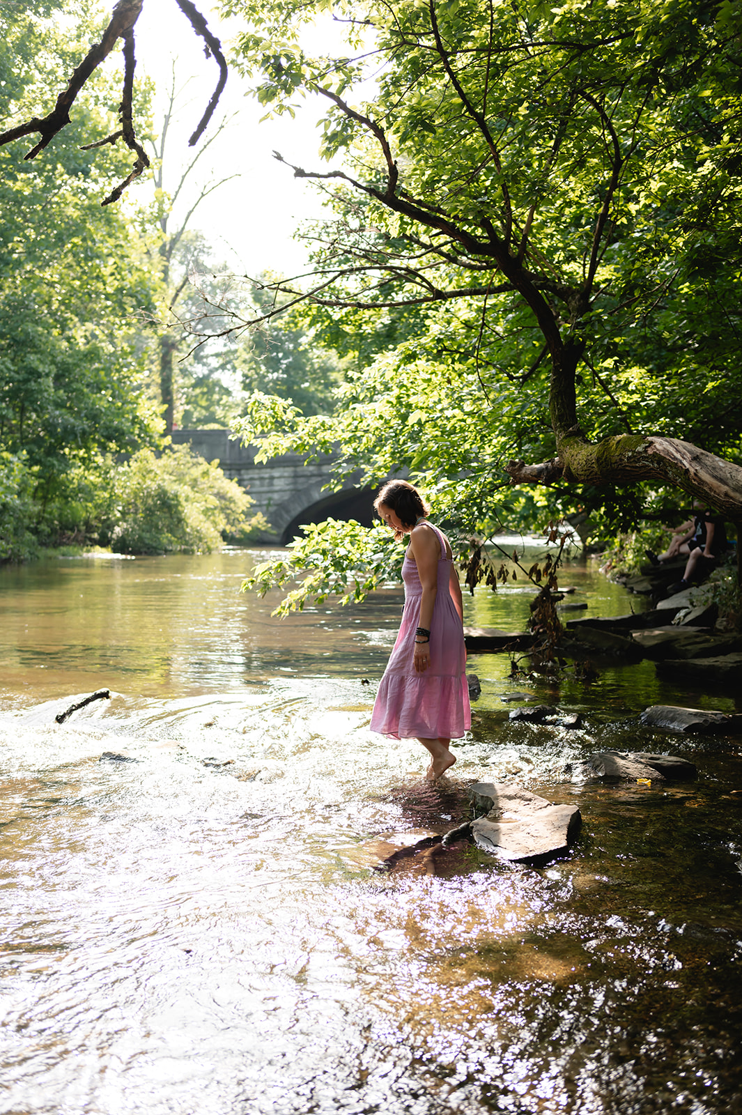 Ana steps into Big Rock Creek as the sun beams overhead.