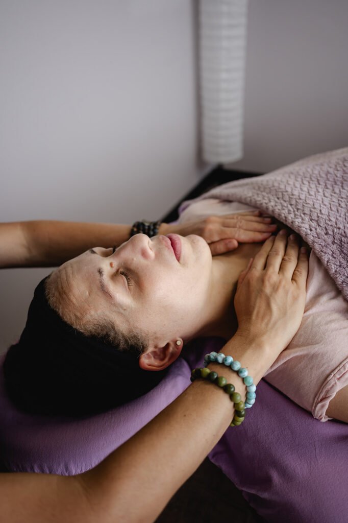 As Ana continues with her session, she places her hands on her client's shoulders.